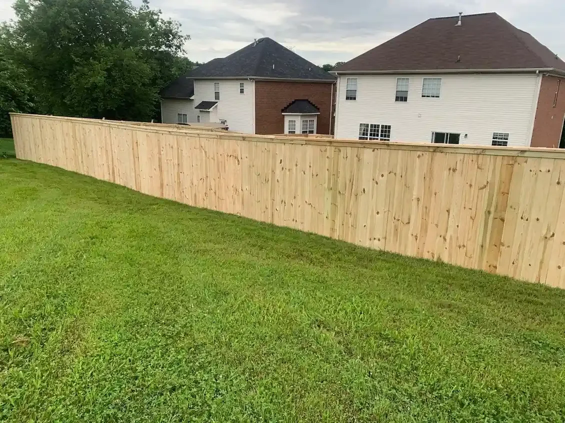 K&C Fence table top wood privacy fence borders a sloped backyard in Lebanon, Tennessee.