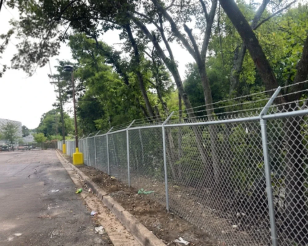 Security chain-link fence with angled barbed wire by K&C Fence in Nashville, Tennessee.