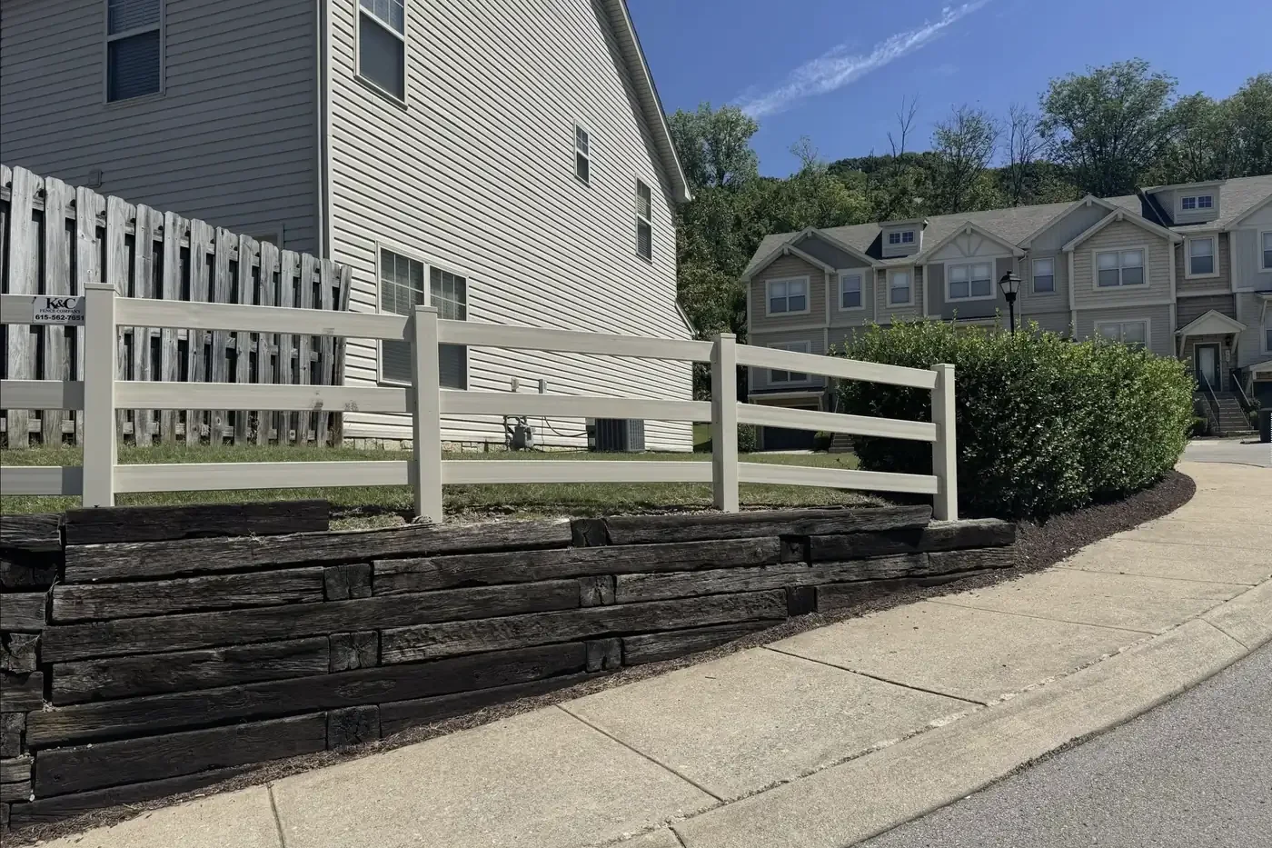 K&C Fence installed a three-rail white vinyl fence above a retaining wall in Nashville, Tennessee.