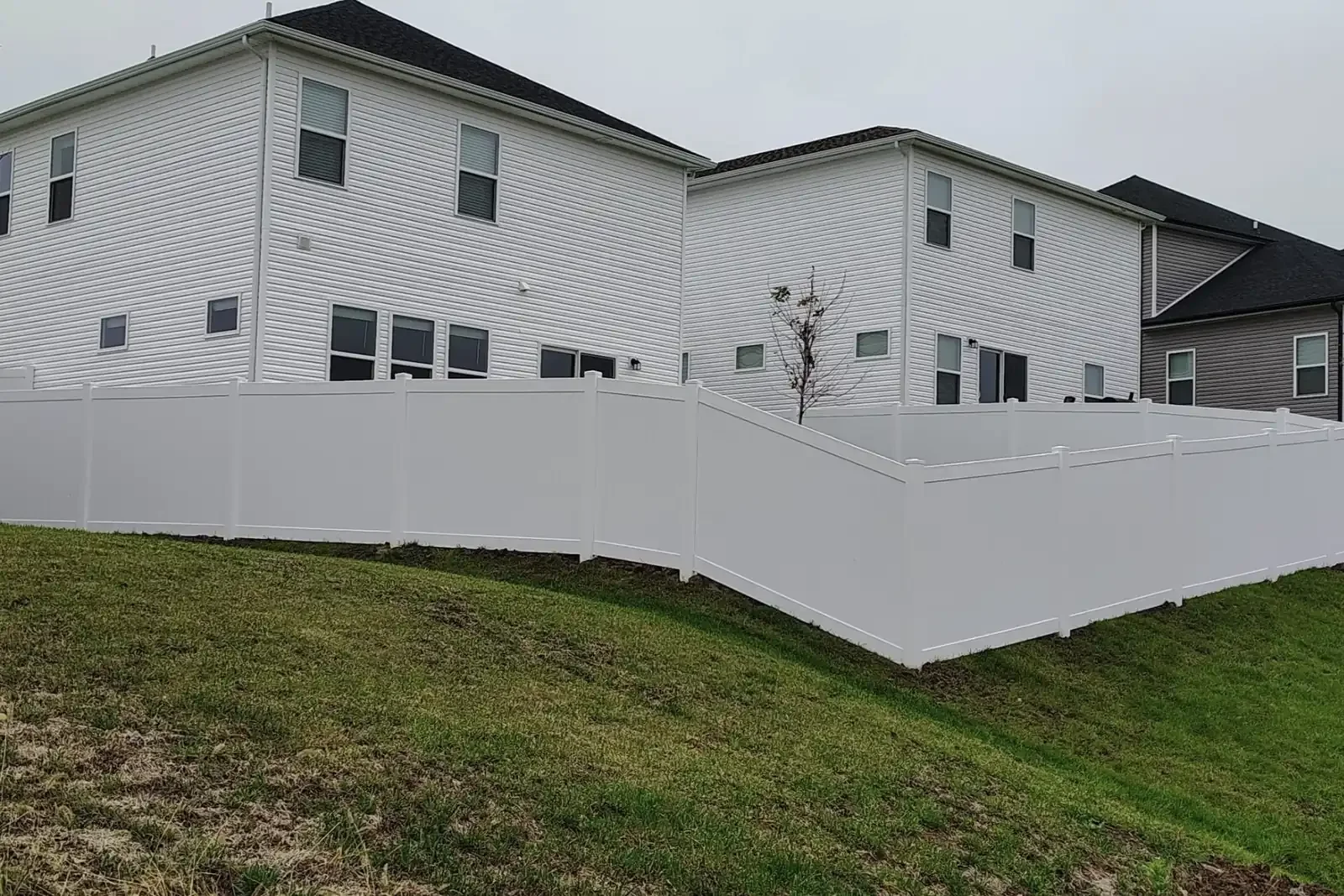 K&C Fence installed a white vinyl privacy fence along a sloped yard in Nashville, Tennessee.