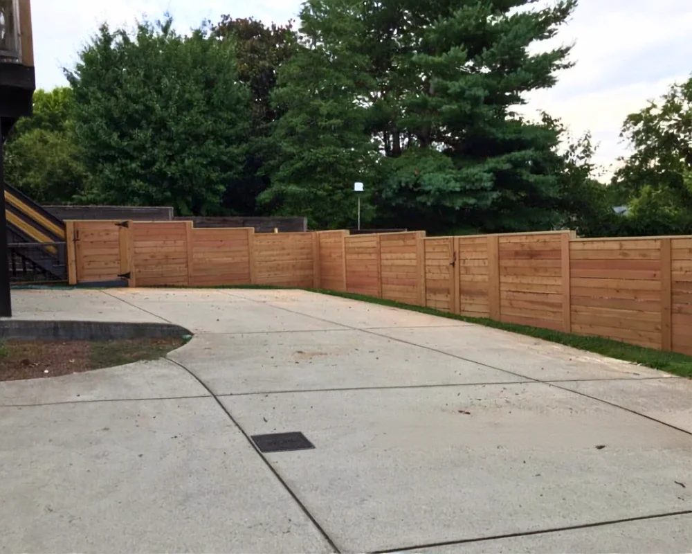 K&C Fence horizontal wood privacy fence with two gates borders a curved driveway in Franklin, Tennessee.