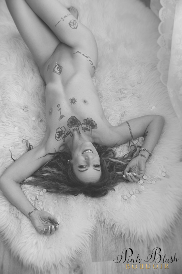 Edmonton Boudoir, a woman laying naked on a fuzzy rug with candy