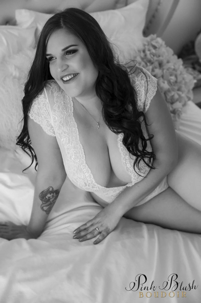 boudoir photography, a curvy woman in a white bodysuit on a bed