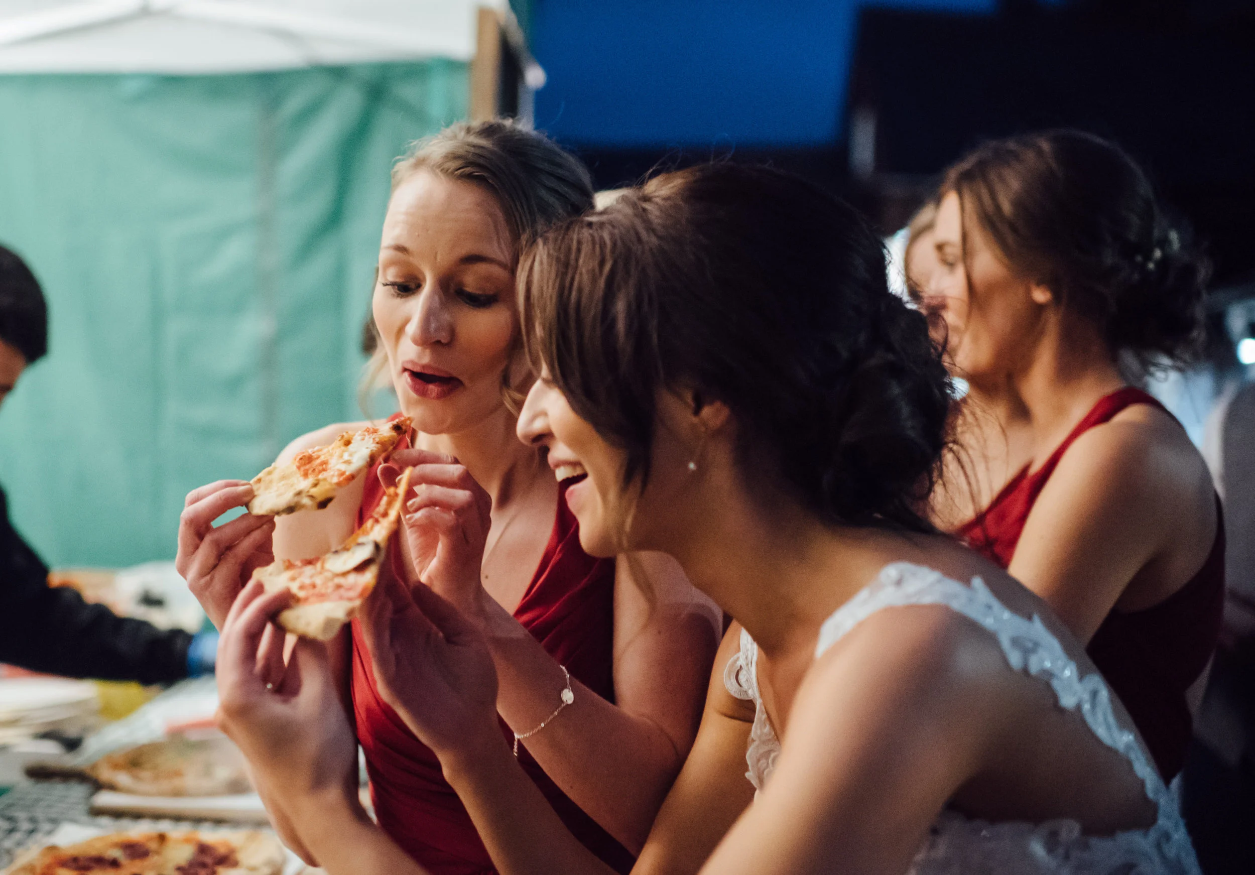 Beautiful bride grabbing a fresh slice of Wedding Pizza