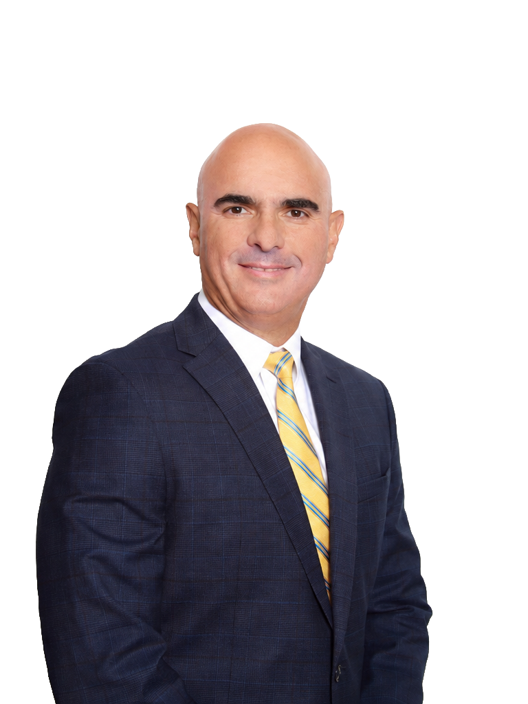 A bald man in a dark plaid suit, white shirt, and yellow striped tie smiling at the camera.