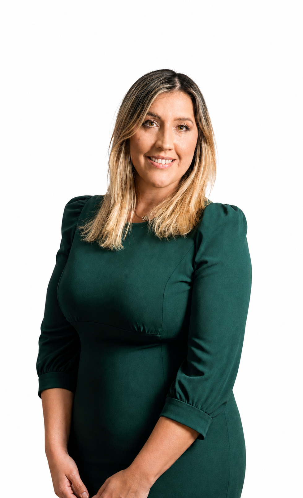 Portrait of a woman with blonde hair wearing a dark green dress, smiling, standing against a white background.