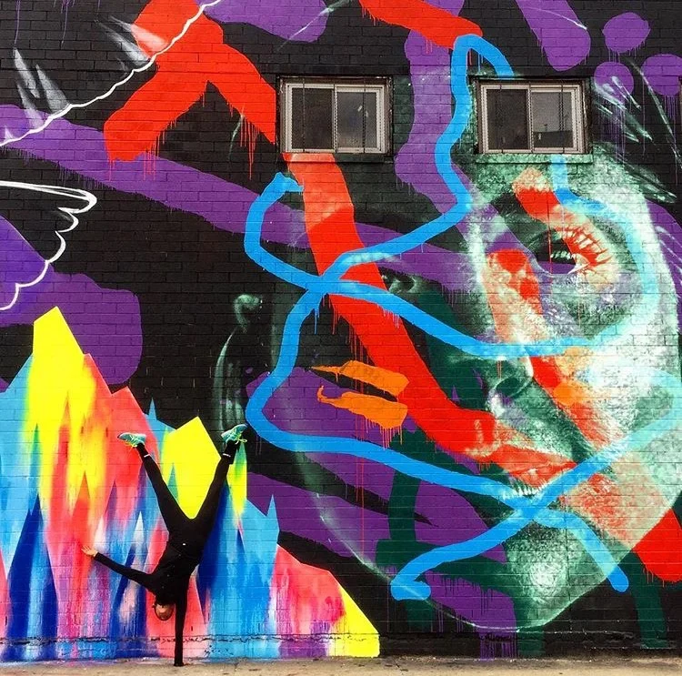 Check out our photo contest first place winner Cara Enright's dope shot in front of a mural by Askew1 and Vexta.