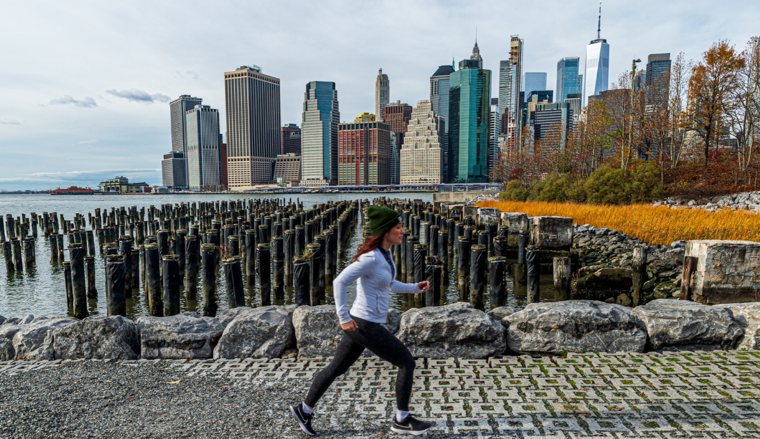 woman cold weather running by nyc skyline in winter