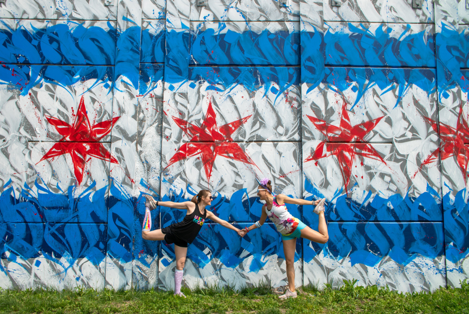 Chicago runners in front of a Chicago flag mural Chicago Marathon spectators