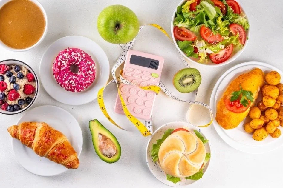 different foods on plates and a calculator and measuring tape