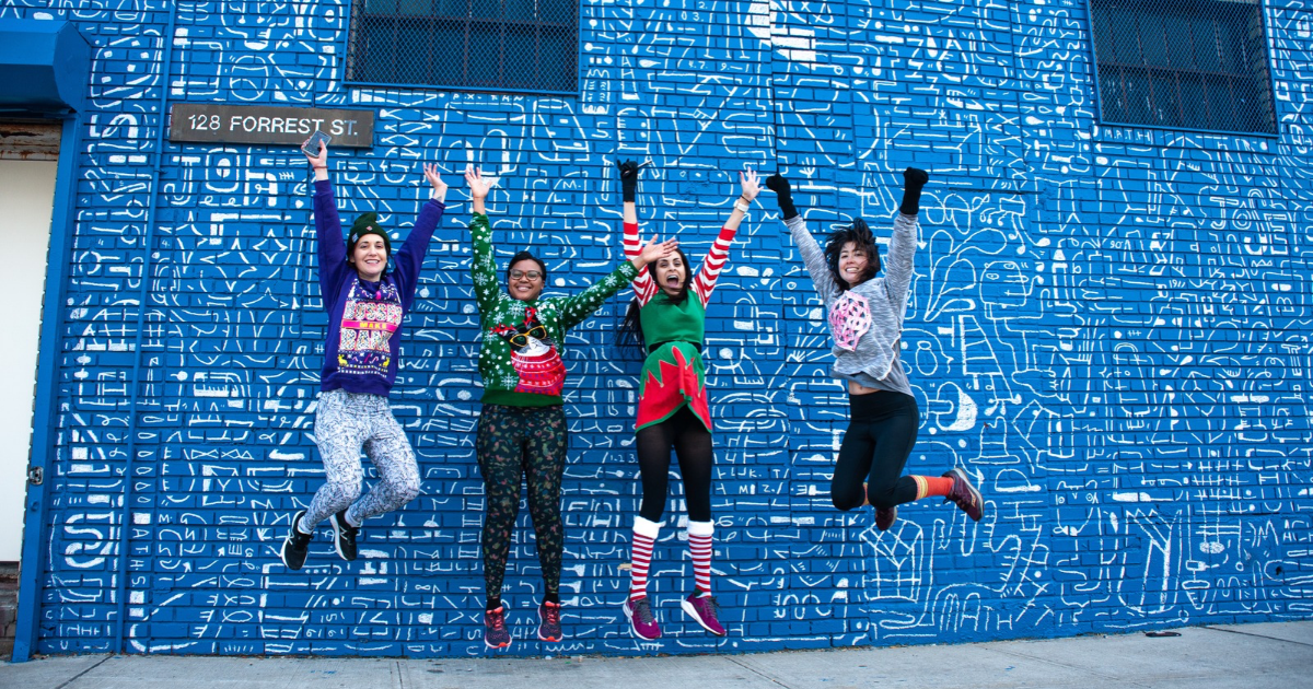 four women runners jumping in holiday clothes winter running in NYC