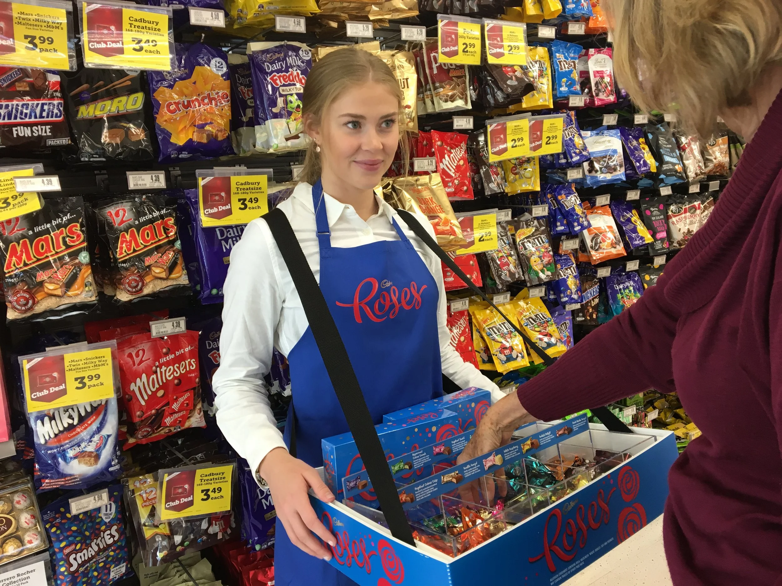Promostaff member sampling Roses with a tray In Aisle in the supermarket