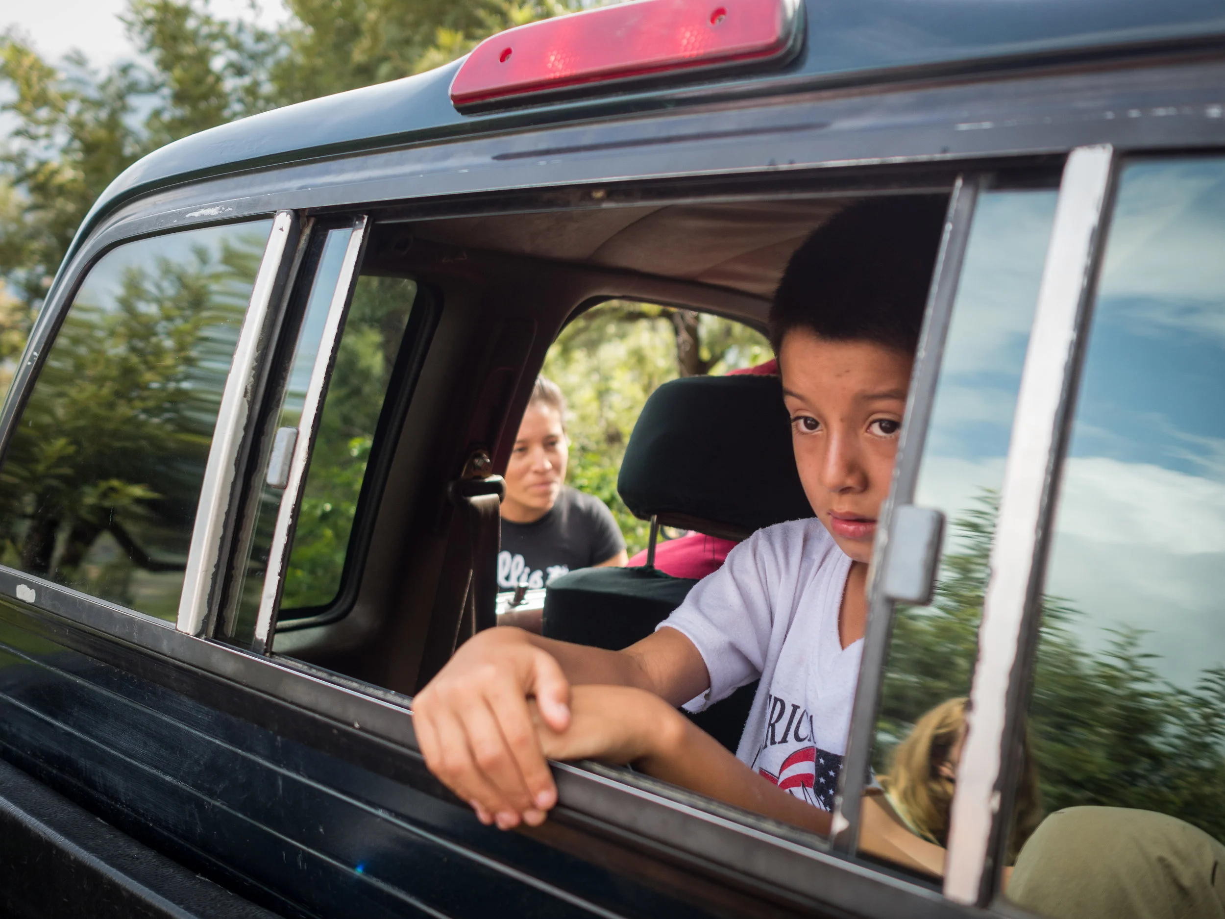Cristian Aguilar Lopez looks out from the back of his fathers truck.