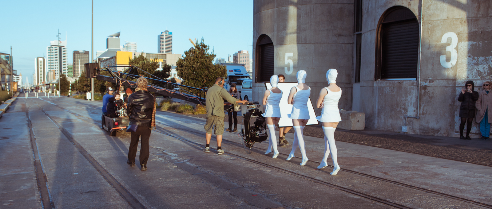 Nurse Me - On location. L to R: Grip Oli Harris, Director Kezia Barnett, DOP Ian McCarroll, Choreographer MaryJane O’Reilly, Grip Assist Mike Reihana, 1st AD Sez Niederer, Nurses Julie Van Renen, Molly McDowell, Maria Munkowits, Gaffer Tom Davis behind the nurses. Far right: Makeup Assist Olga Gill and Makeup Artist Verity Griffiths