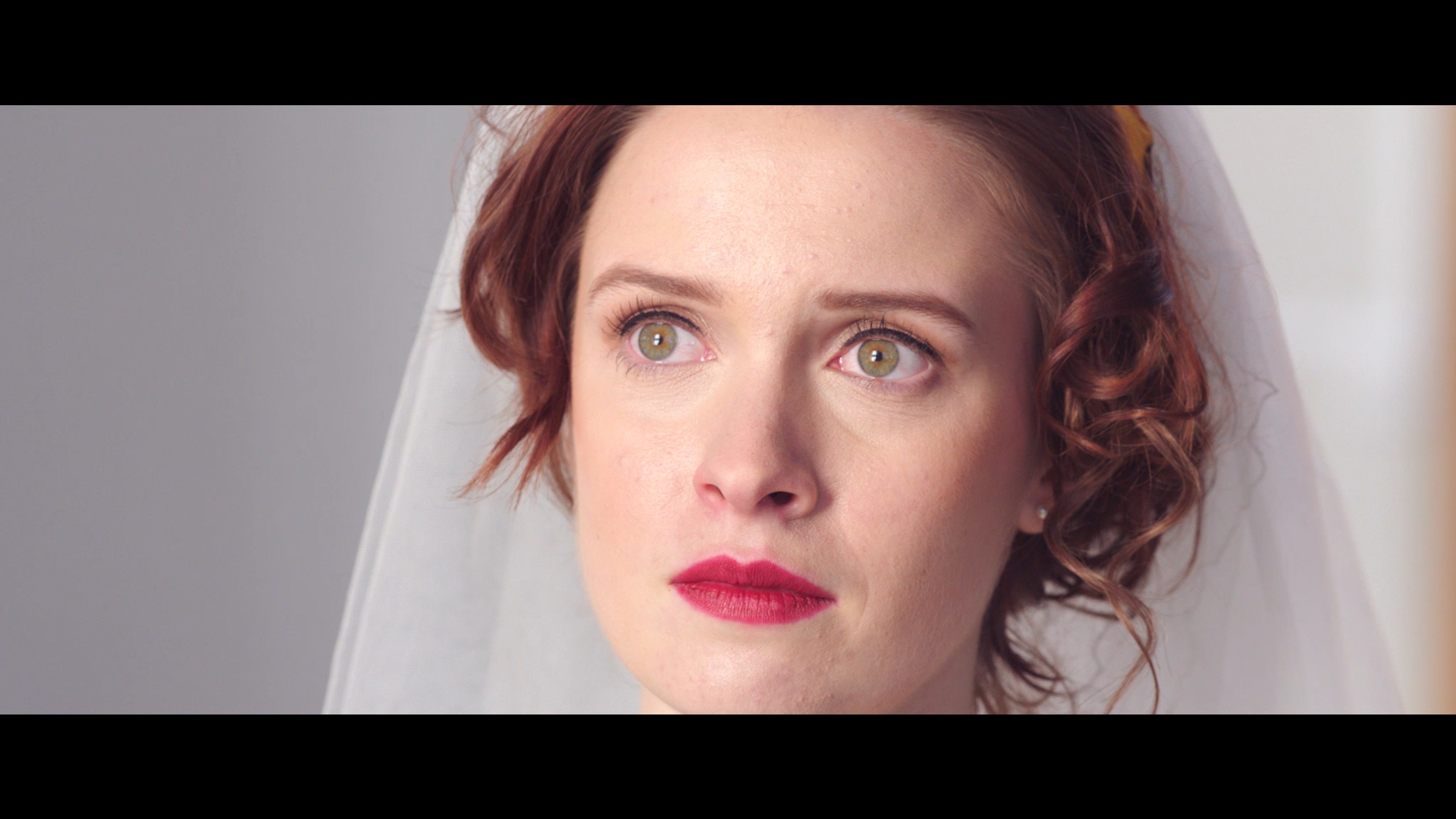 Emily (Sarah Swire) is at the altar.