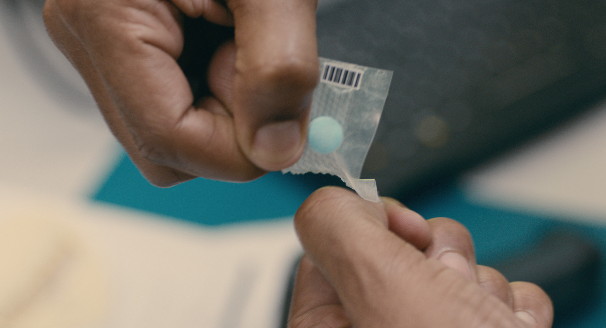Adherence - Nurse Nate tears open a sealed medication to administer to Daniel.