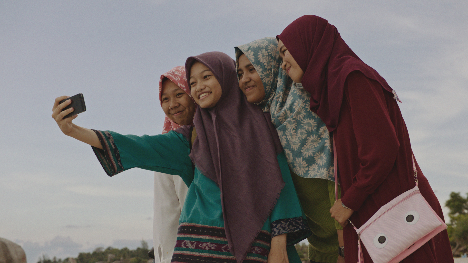 Bottom: Nuha takes a selfie with friends