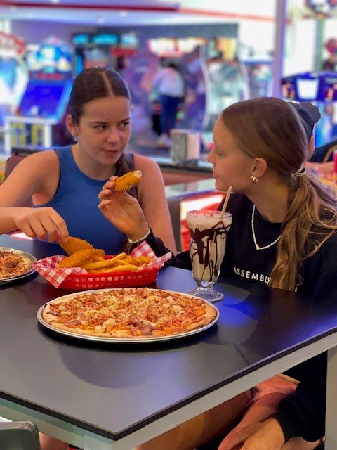 two girls eating pizza.jpg