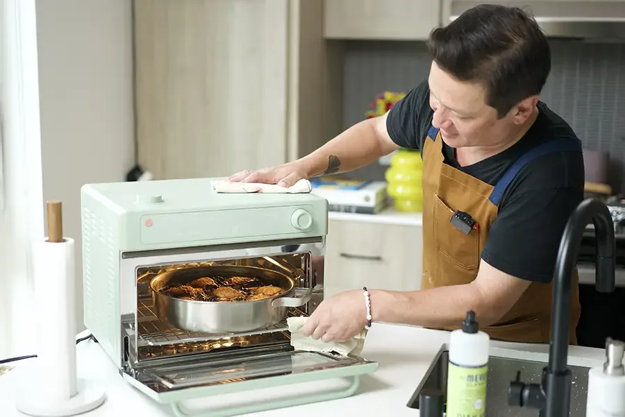 Kenji López-Alt slides his Our Place braiser full of chicken into his Our Place Wonder Oven Pro