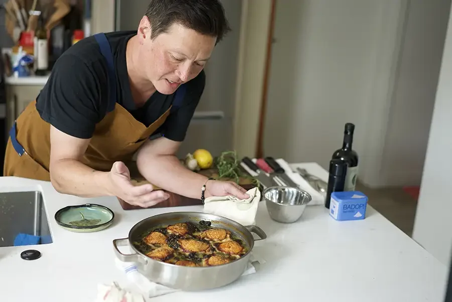 Kenji López-Alt shows off browned chicken thighs cooked in his Our Place braiser.