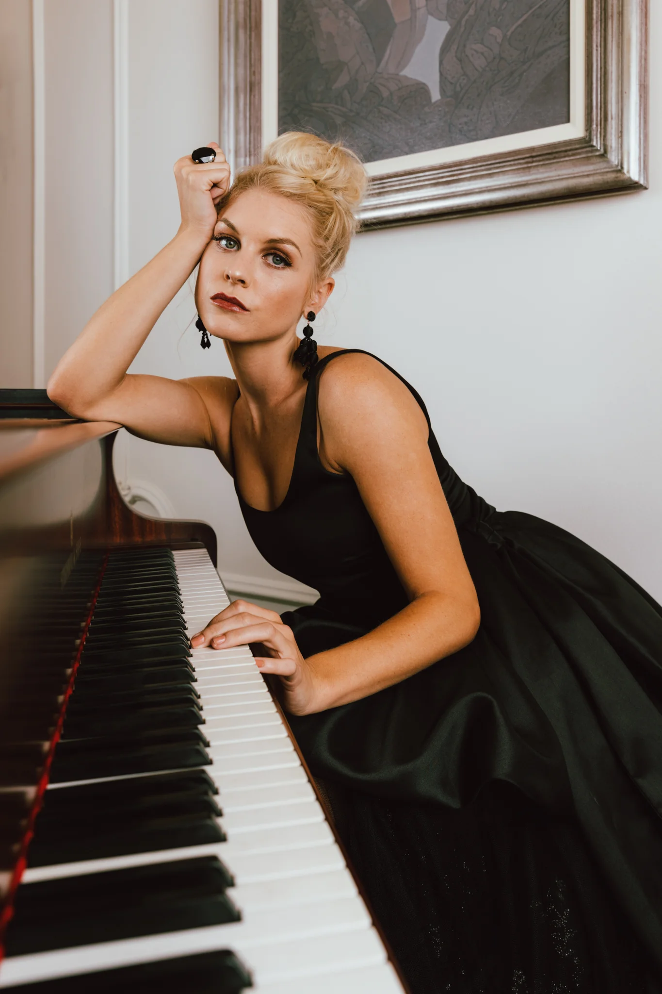 Girl leaning on piano in black KluK CGDT dress at Ellerman House