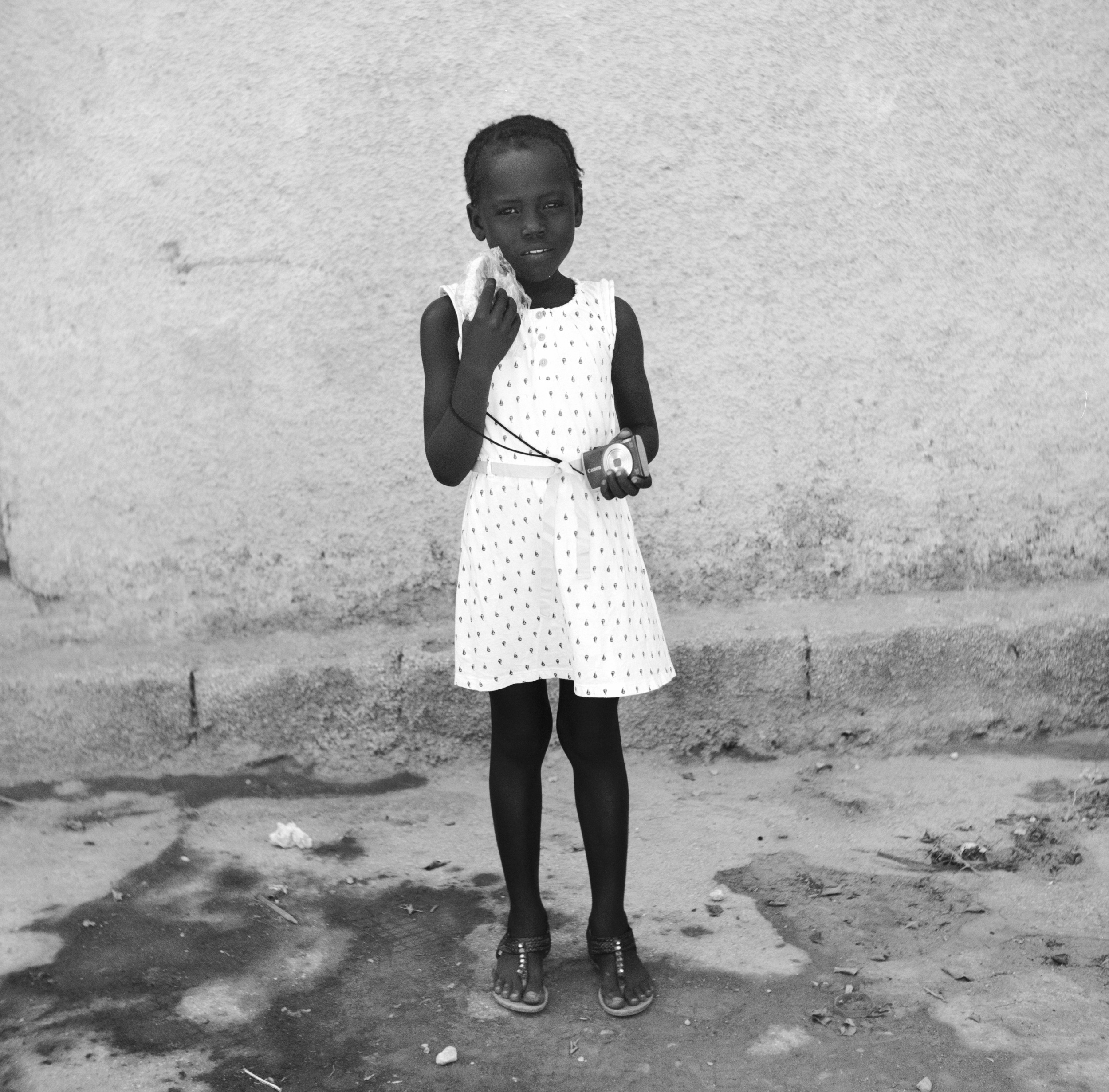 Saint Jean, Gonaïves- The same reluctant girl from the previous photo poses with a Lidè provided sandwich and camera.