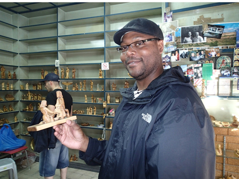 Tim shops for an olive wood figurine.