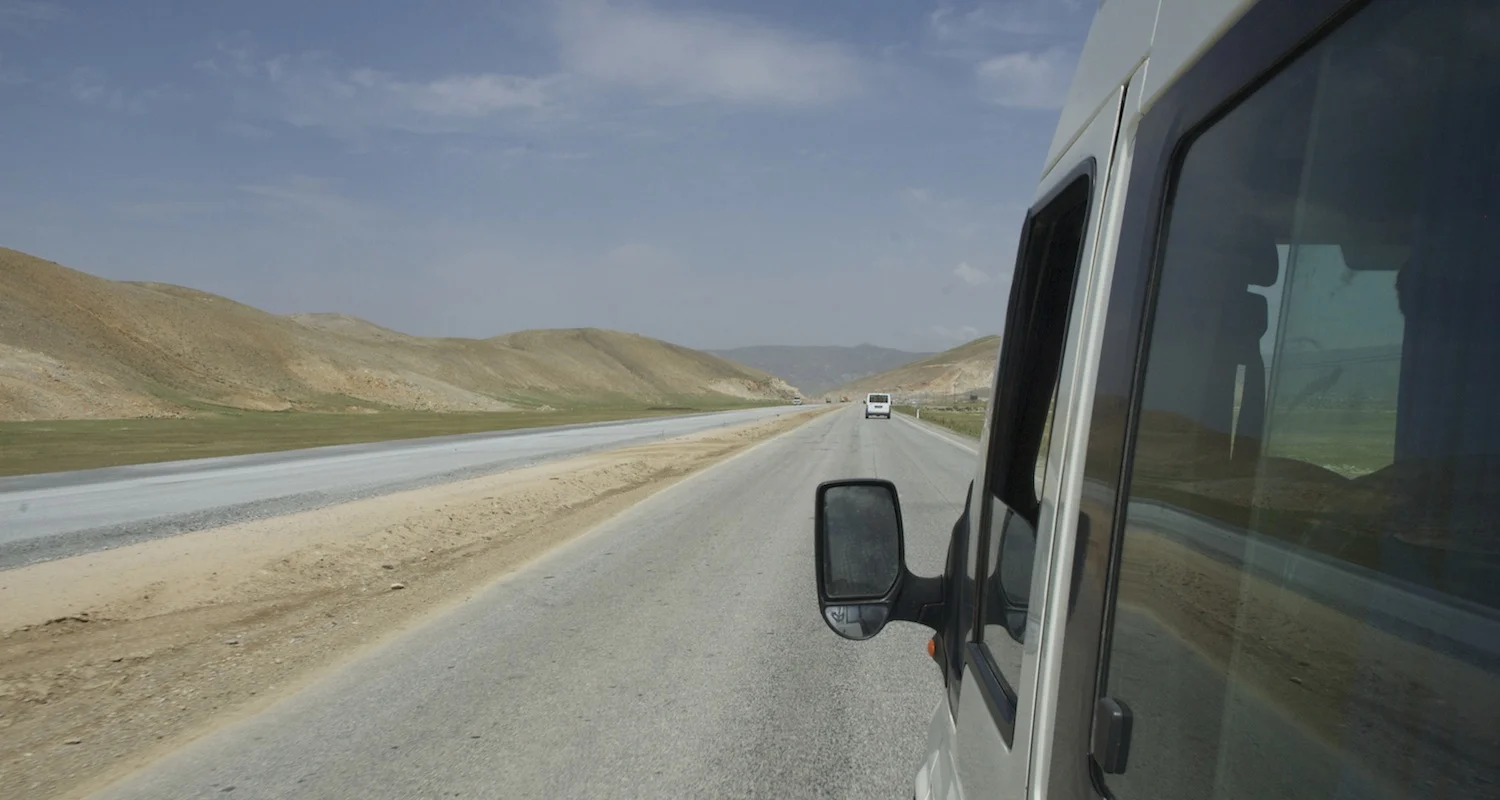 The road unwinds before us.
