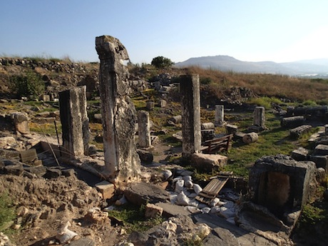 View to the entryway cut from a single stone. The modern bench sits inside it.