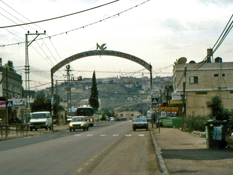 The “Welcome to Kana” sign hangs over the main street and greets visitors in English, Arabic, and Hebrew.