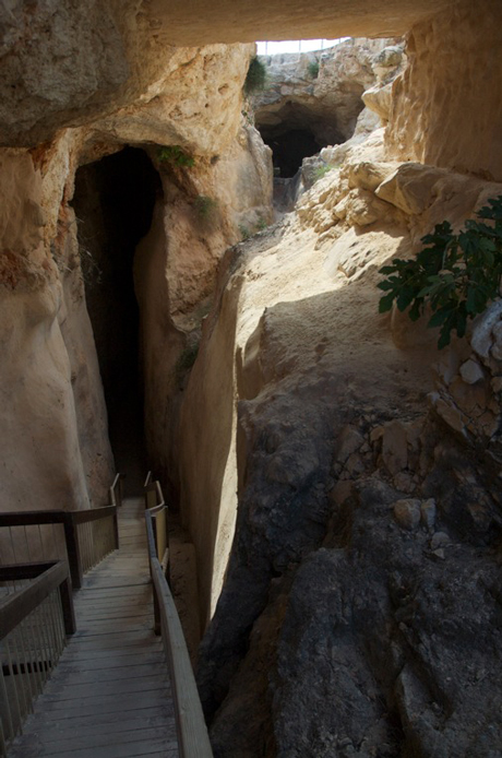 The path steps down between plastered walls. Water still collects here in places.