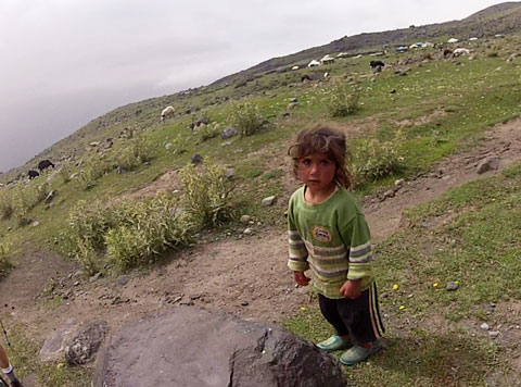 A child on the trail. Note the campsite and animals on the horizon.