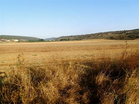 View to harvested fields beside the road. Note the large bales in the distance. The valley floor is covered with colluvial sediments washed down from the hillsides.