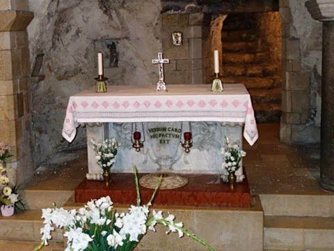 The modern altar in the cave. Note the black letters between and candles and below the altarcloth.