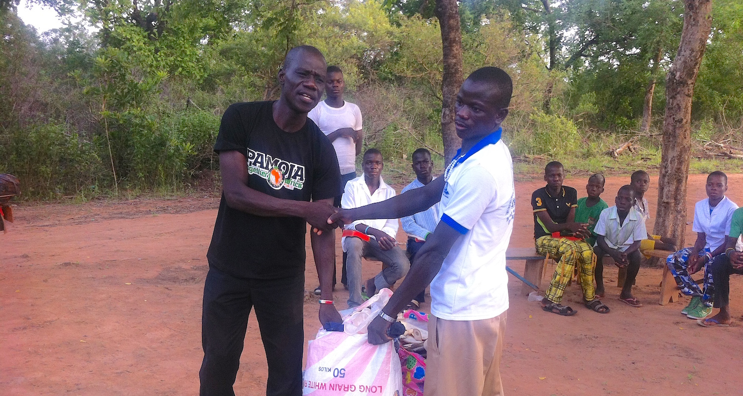 Pastor Philip (on left) helping distribute clothing.