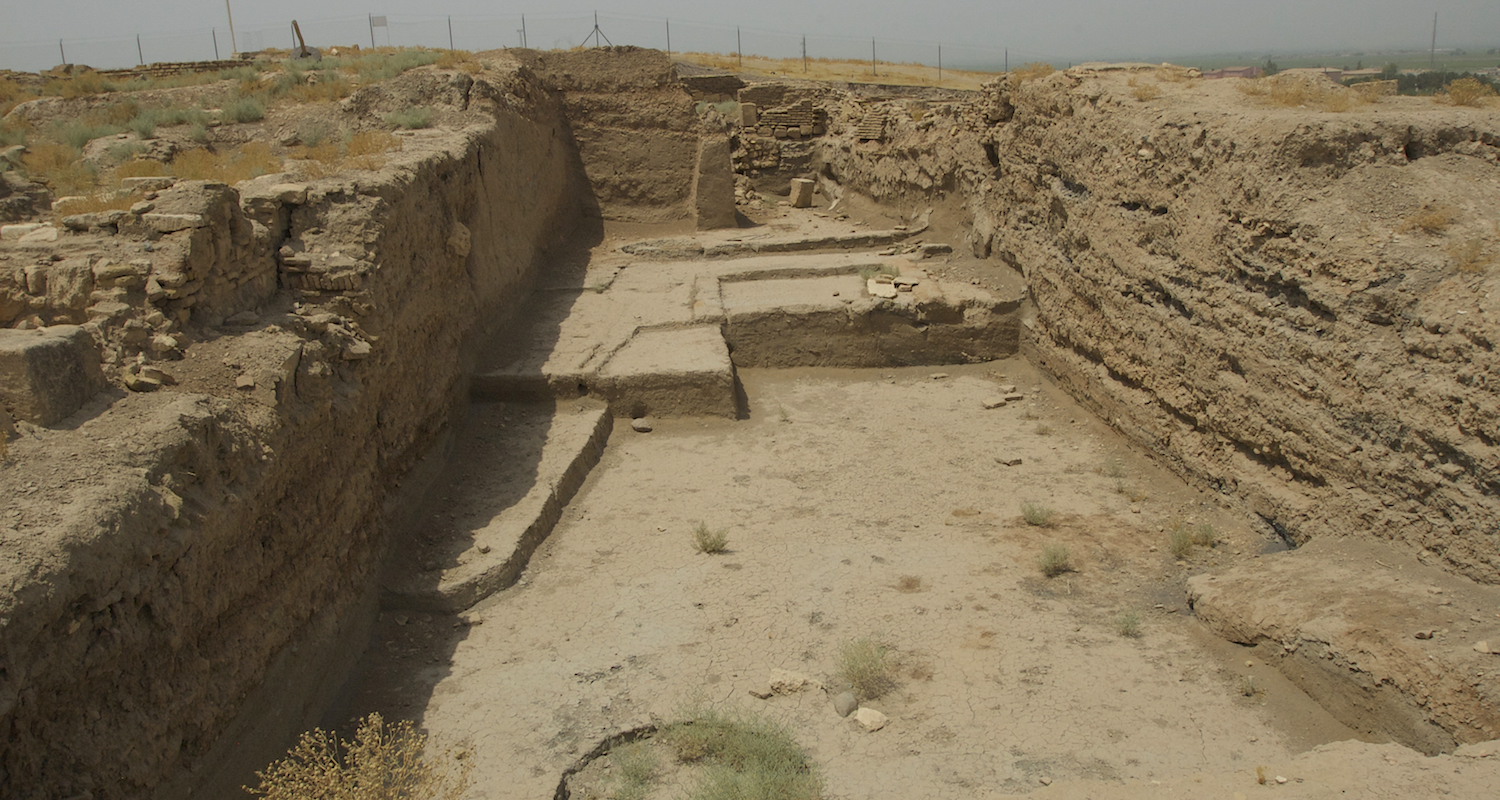 View through a chain-link fence to a recently excavated area of Haran.
