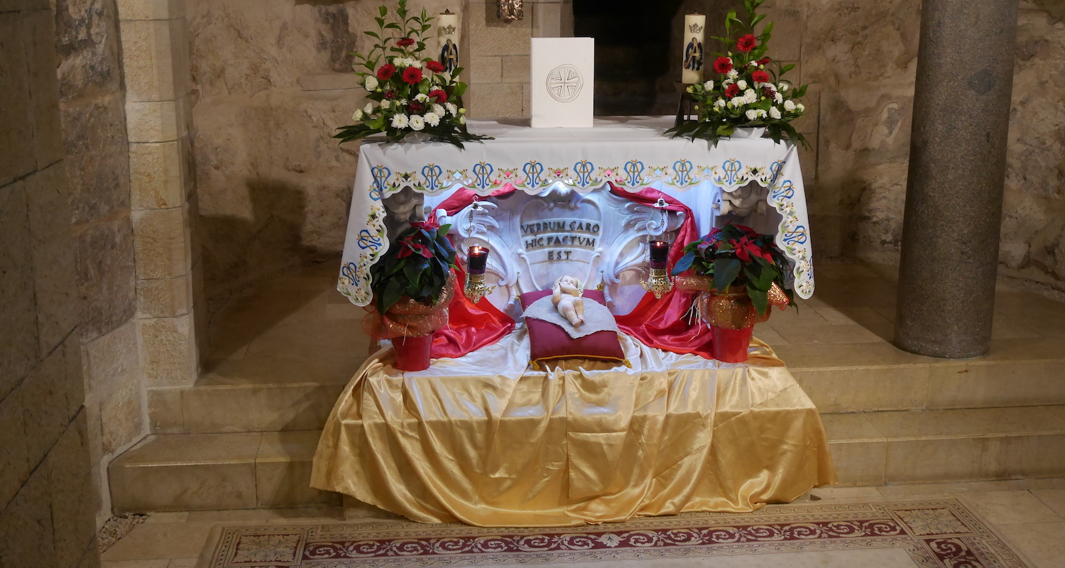 Every church we visited was festively decorated in the colors of the season. Here, at the altar where tradition suggests that Mary received the announcement that she would bear a son, a model of the Christ-child is flanked by colorful poinsettias.