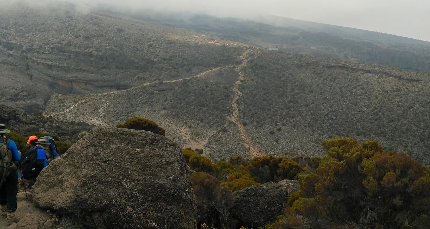 We spotted the camp on the far side of the Karanga Valley. The trail climbing out on the right is the line we sought to follow. The trail climbing out on the left is the trail used by the porters to fetch runoff water for the camp.