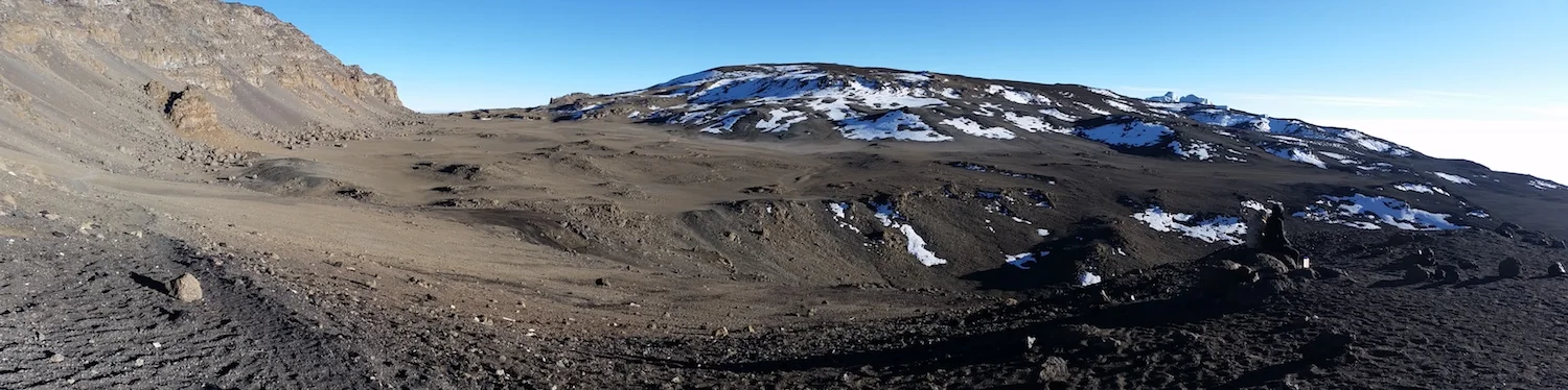 A natural amphitheater. I shot this panorama to Kibo's rolling top on on my descent. Reusch Crater rises with snow patches in the center of the image. The highest point on the mountain is Uhuru Peak, off screen, to the upper left.