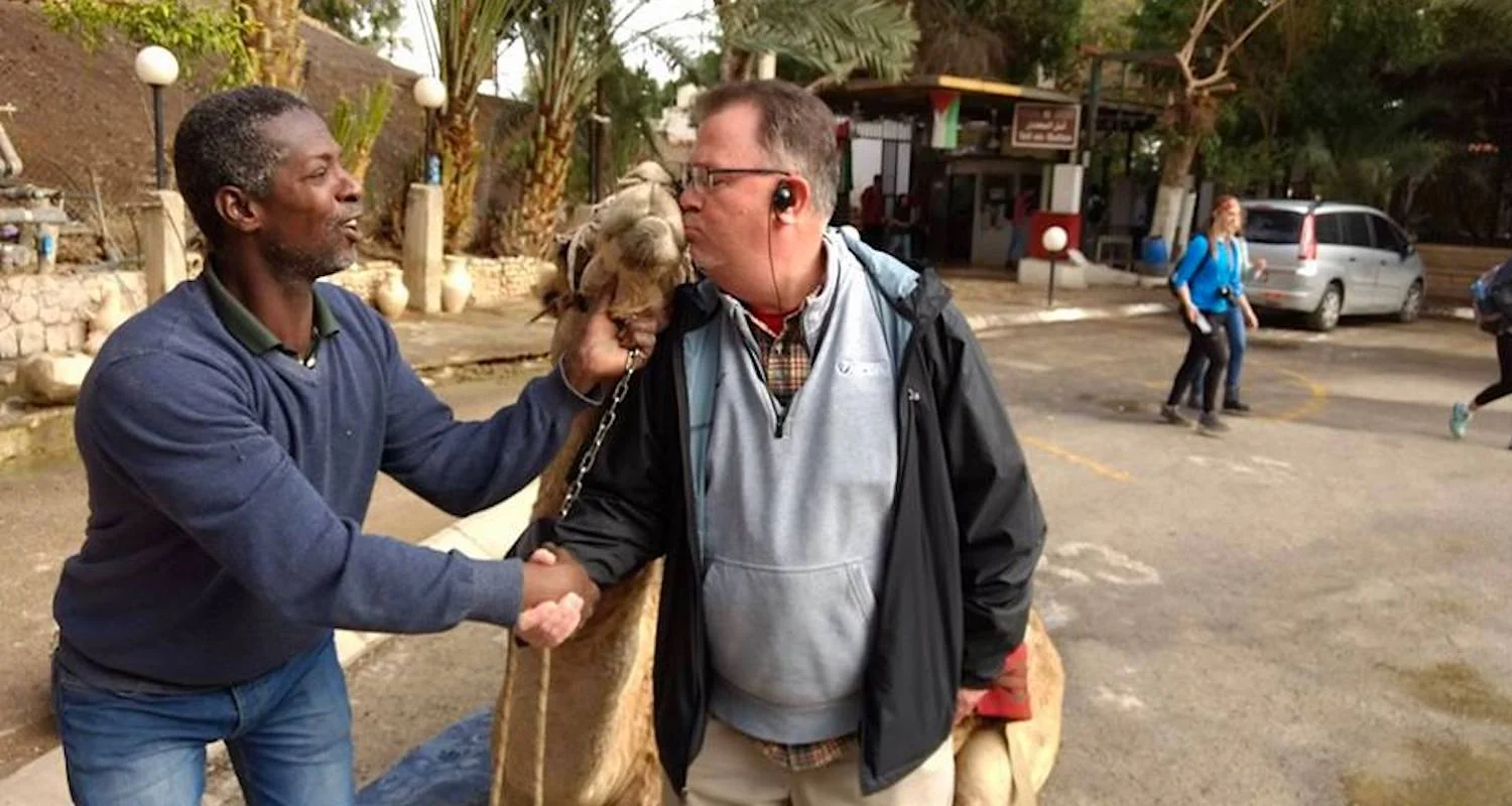 An Indiana pastor experiences his first camel kiss in the parking lot beside old Jericho. Photo by Bible Land Explorer Byron Williams.