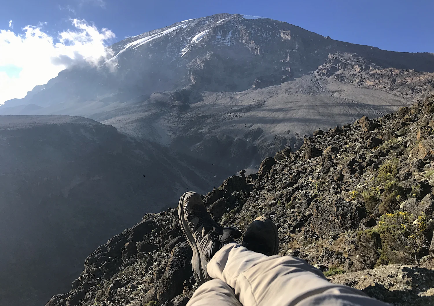 It’s not the most comfortable napping spot on the mountain, but the view is without rival. Kibo, the central cauldron of Kilimanjaro, rises in all its fuming glory.