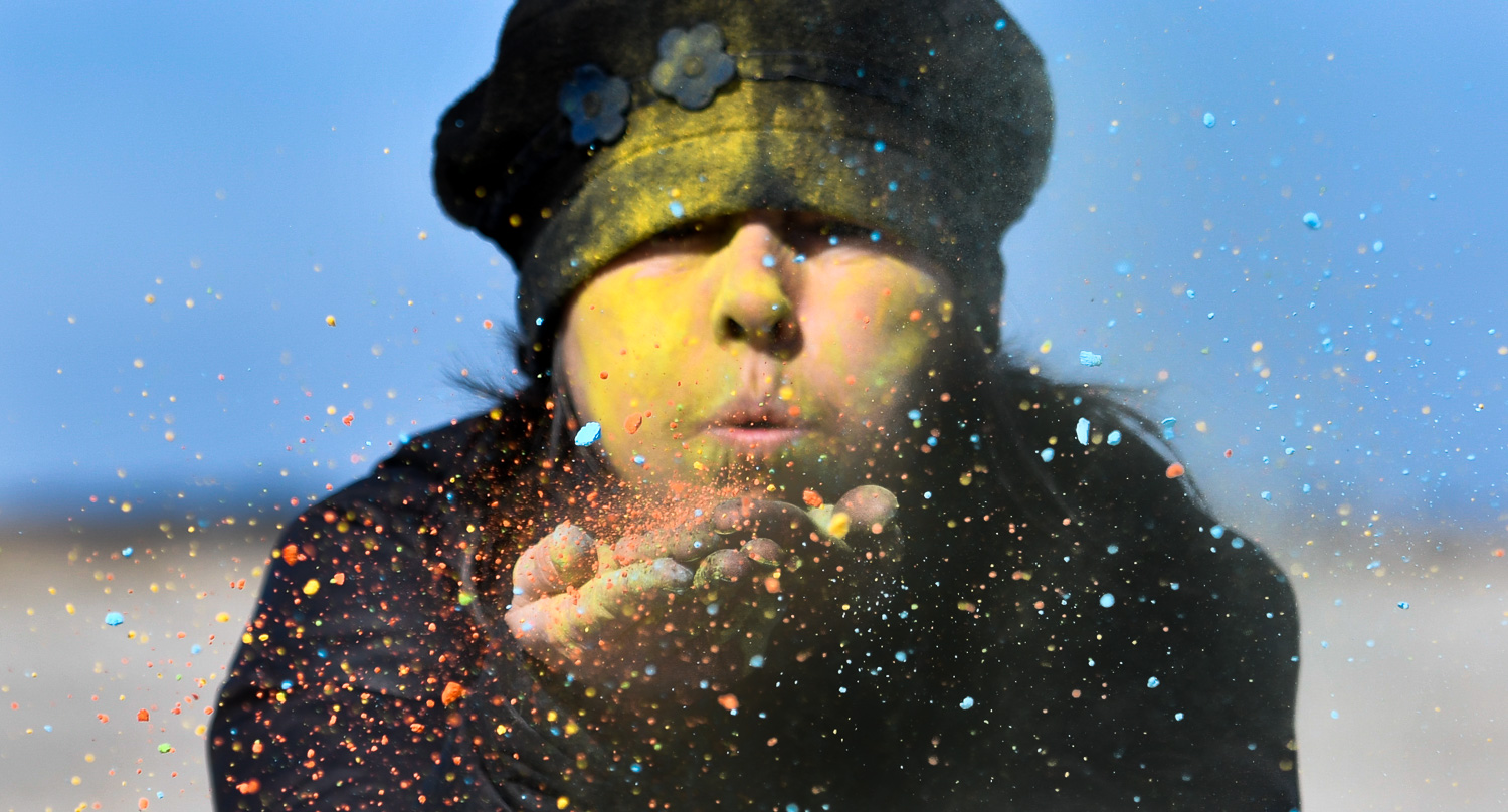 Nikon D500, 1/2500 @ f/4, ISO 100, 70-200mm Kerrie Bates, Director of Ipswich ReCreation and Culture, blows colored powdered cornstarch into the air to promote the upcoming Ipswich Spring Equinox Extravaganza at Crane Beach in Ipswich.