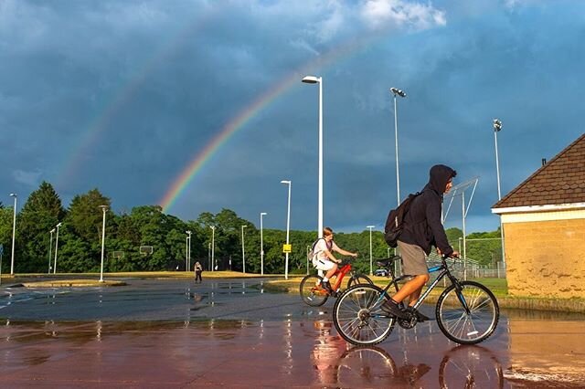 Two boys on bicycles ride under a rainbow cast over the Belmonte Middle School parking lot in Danvers on Wednesday, June 24, 2020. [Wicked Local Photo / David Sokol] #wickedlocalpix #wickedlocal #gannett #danversma #rainbow