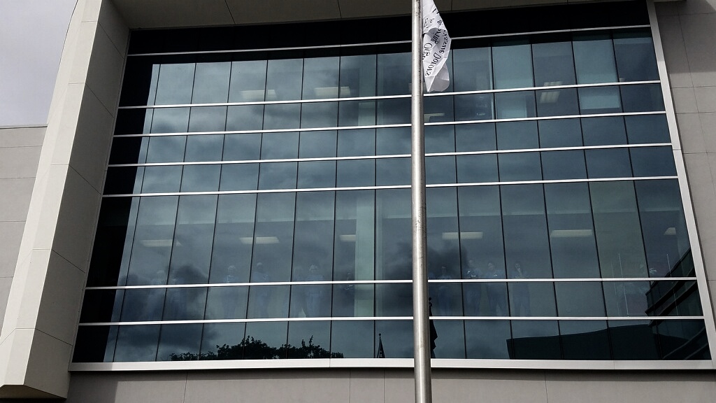 Hospital staff looks on from above as the Donate Life Flag is raised to honor Baby Clark Decell.