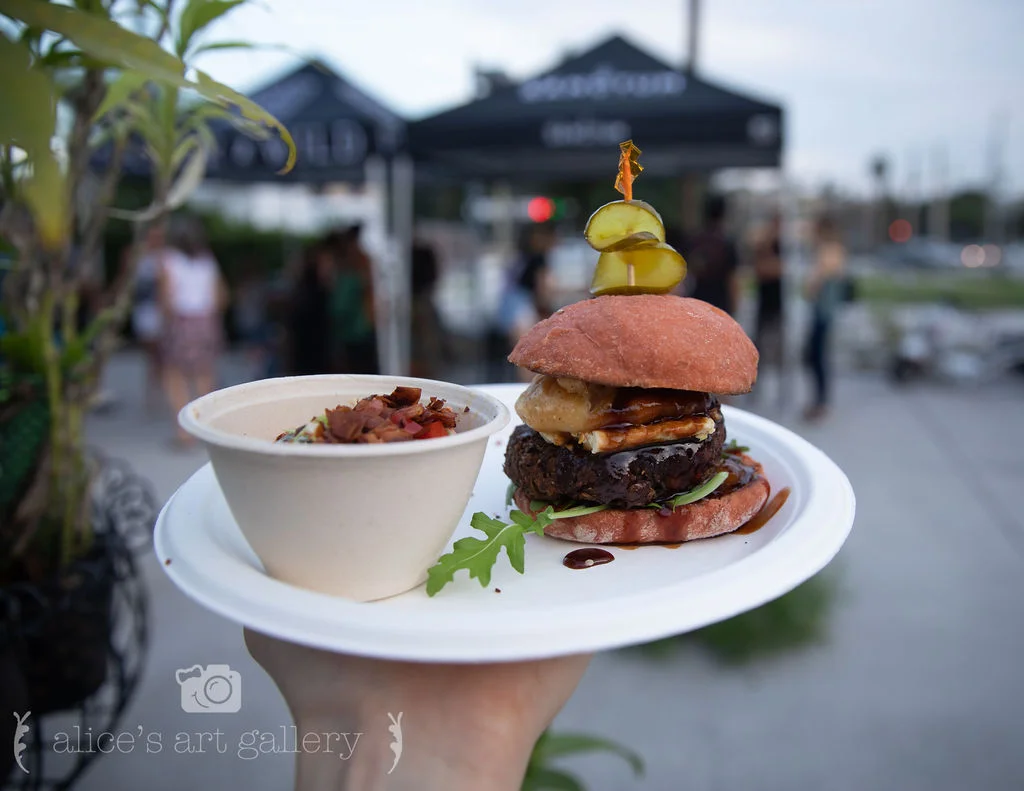 Kelsey (representing The Sanctum): It’s called "The Apple Jack" because it has apple chutney and pepper jack cheese. On top of the patty was a fried onion ring with the pepper jack cheese, then drizzled with BBQ sauce. What was especially cool about Kelsie's burger was that she made her pink buns from scratch, and it was topped with a spicy sweet pickle. Her side dish: Buttermilk Brussel Slaw.