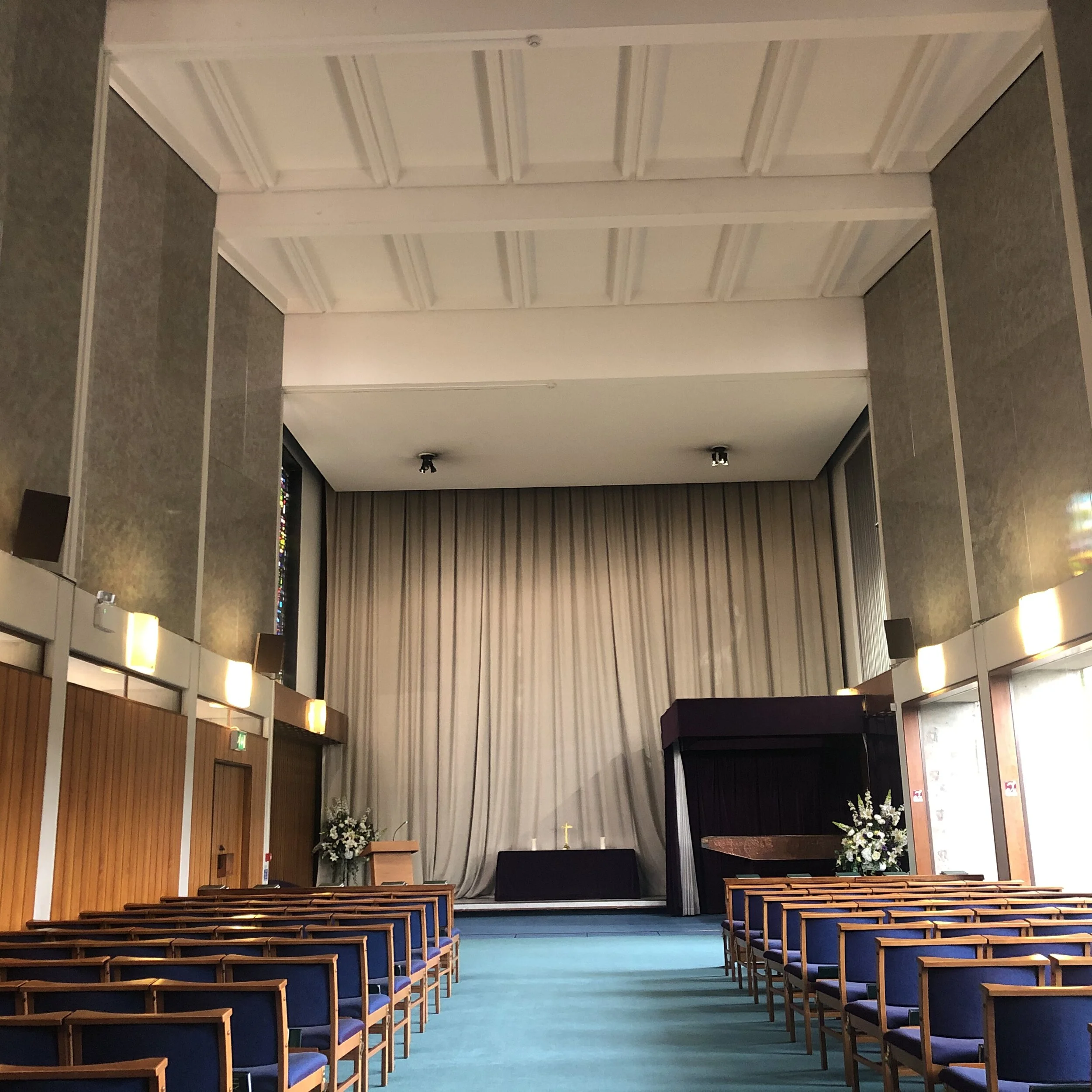 Wider view of the East Chapel, showing its high ceiling, seating and front of the room