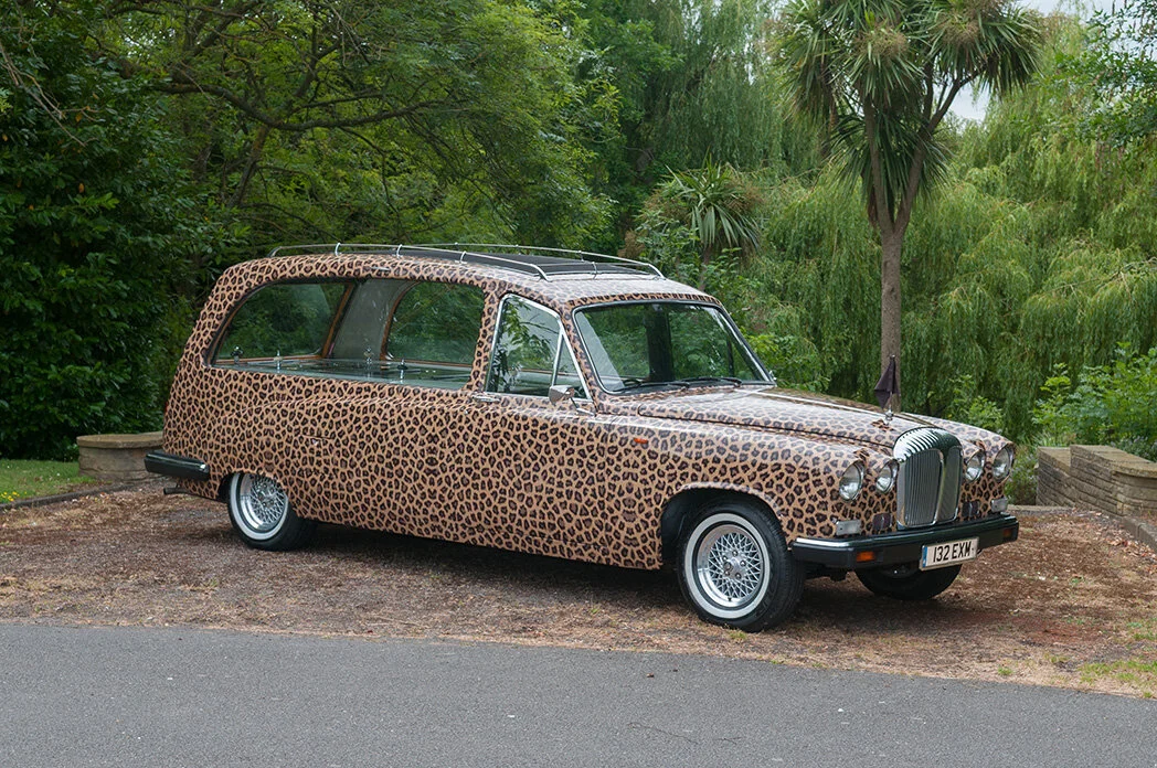 Leopard-print vintage Daimler hearse photographed from the side