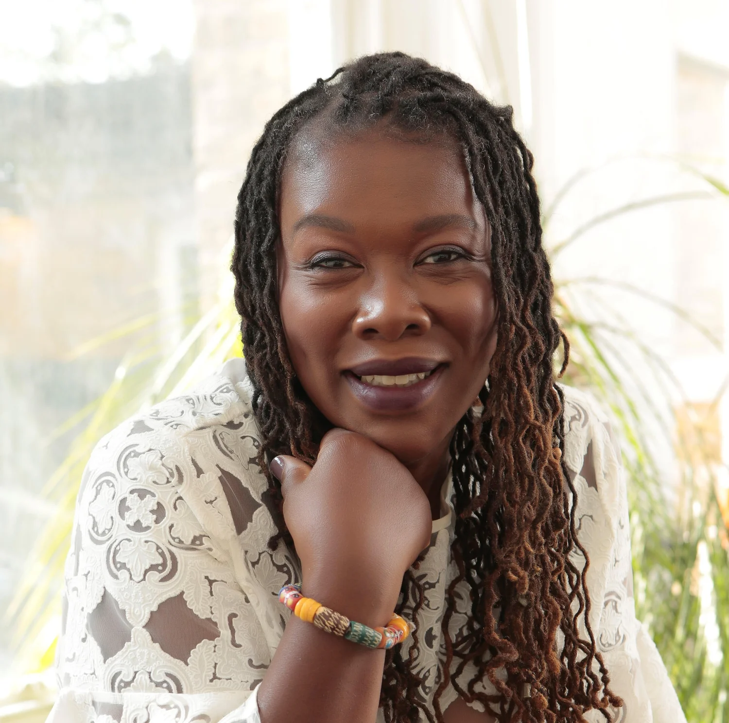 Portrait of funeral celebrant Debi Roberts, smiling with her chin resting on her hand