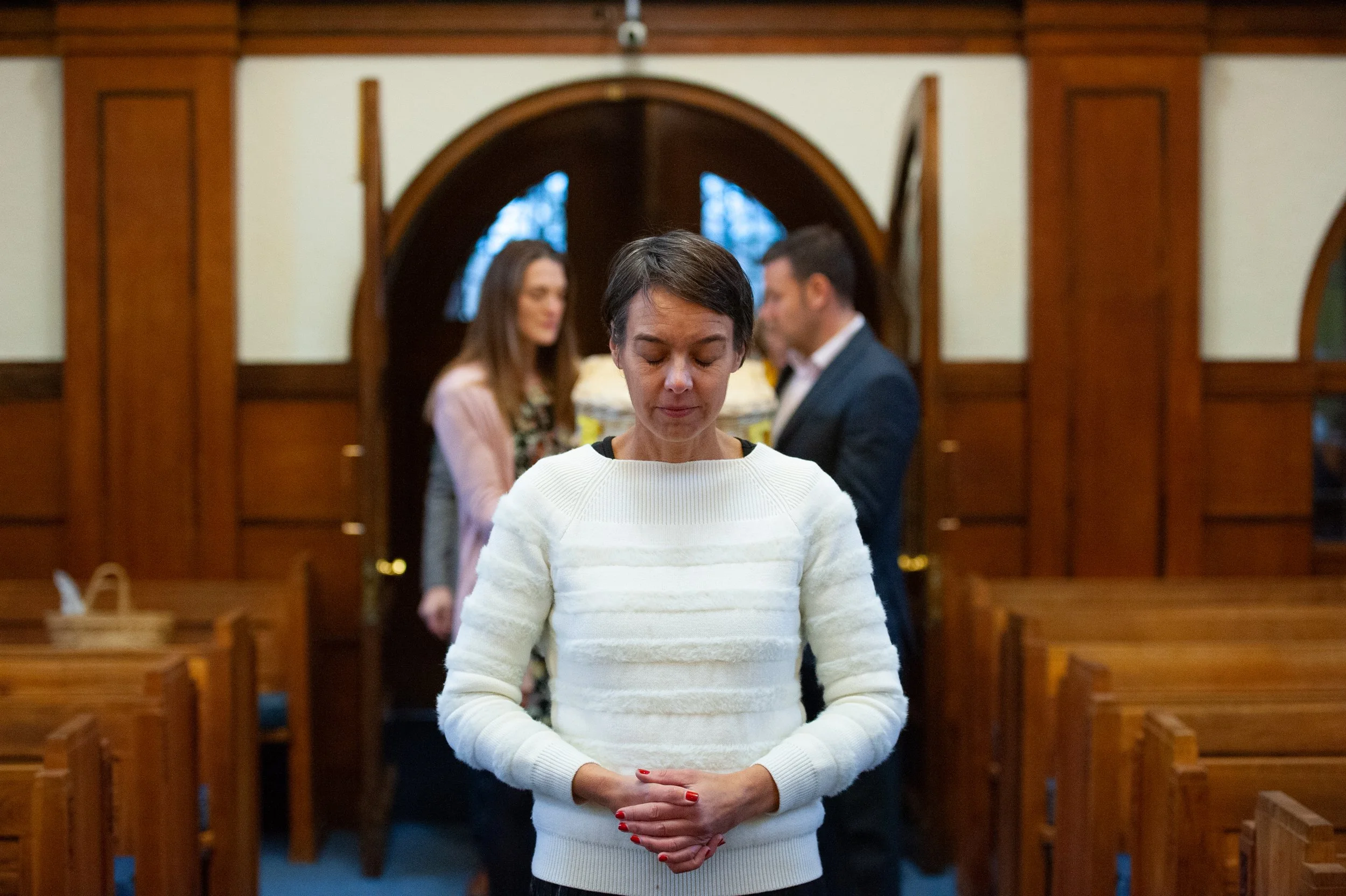 A person standing quietly in the chapel before a funeral