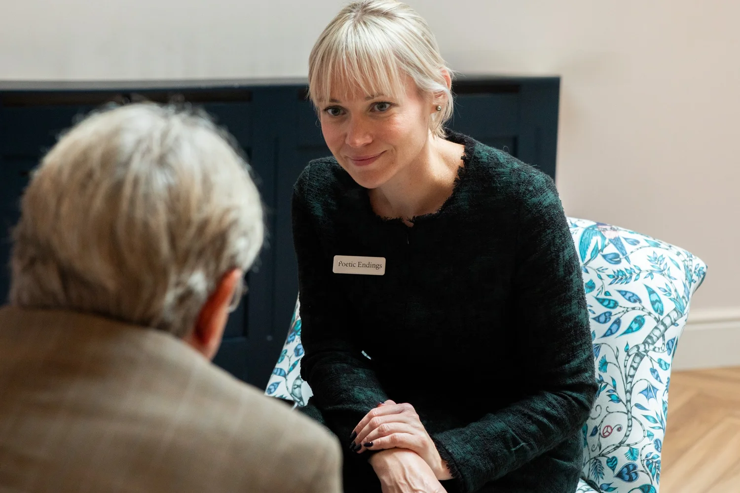 A smiling Poetic Endings funeral director talking with a visitor